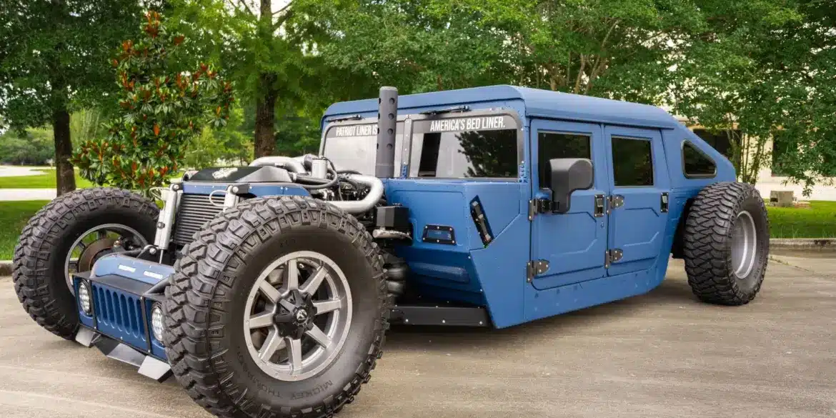 Offener, radikal umgebauter Humvee von 1987 in Blau mit markanter Schutzbeschichtung, offener Motorpräsentation und massiven Offroadreifen.