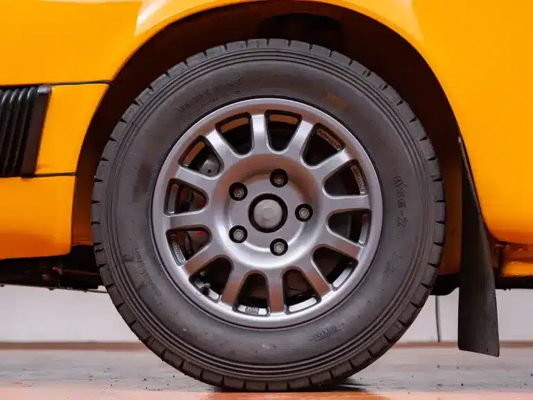 Nahaufnahme eines 15-Zoll-Geländerads an einem gelben Porsche 911 Safari Umbau, mit Offroad-Profil und verstärktem Reifen.