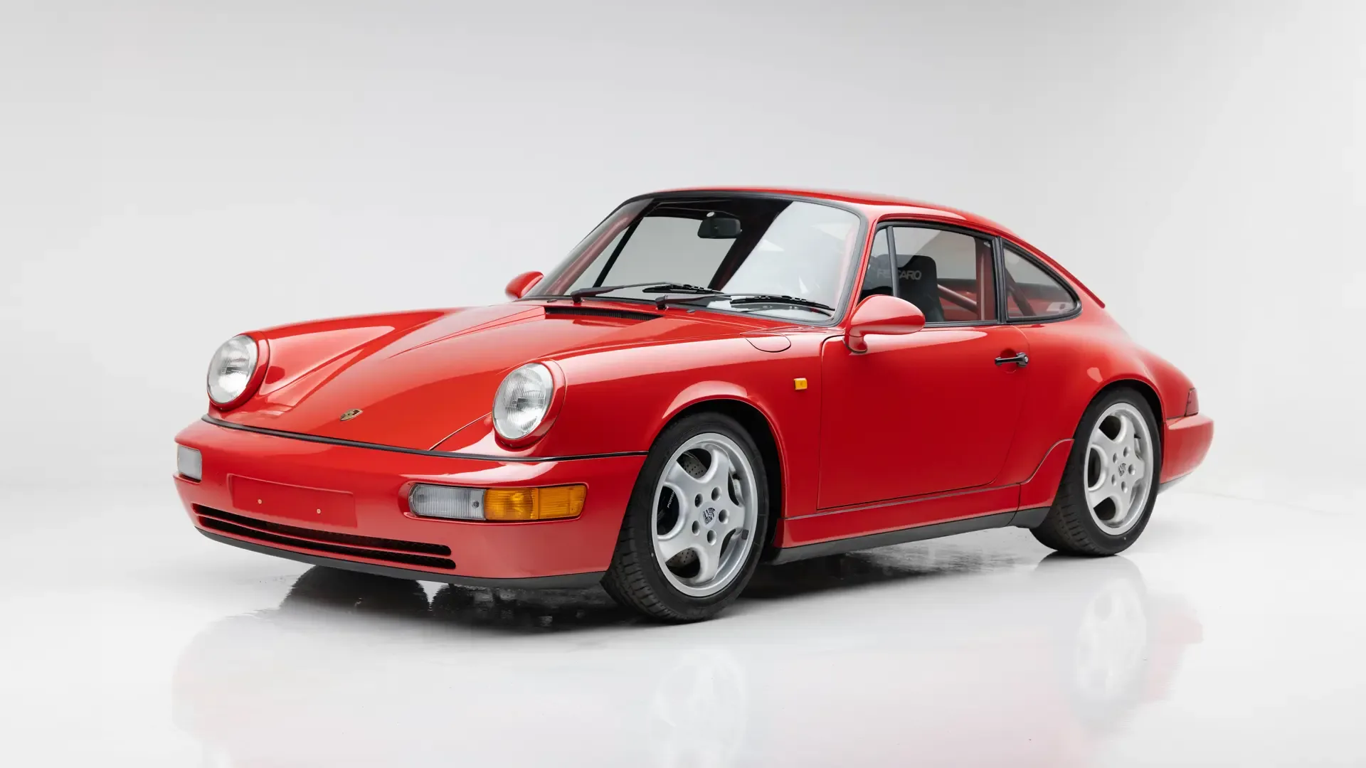 Roter Porsche 911 Carrera RS N/GT (964) von 1992 in einem Fotostudio, Frontansicht.