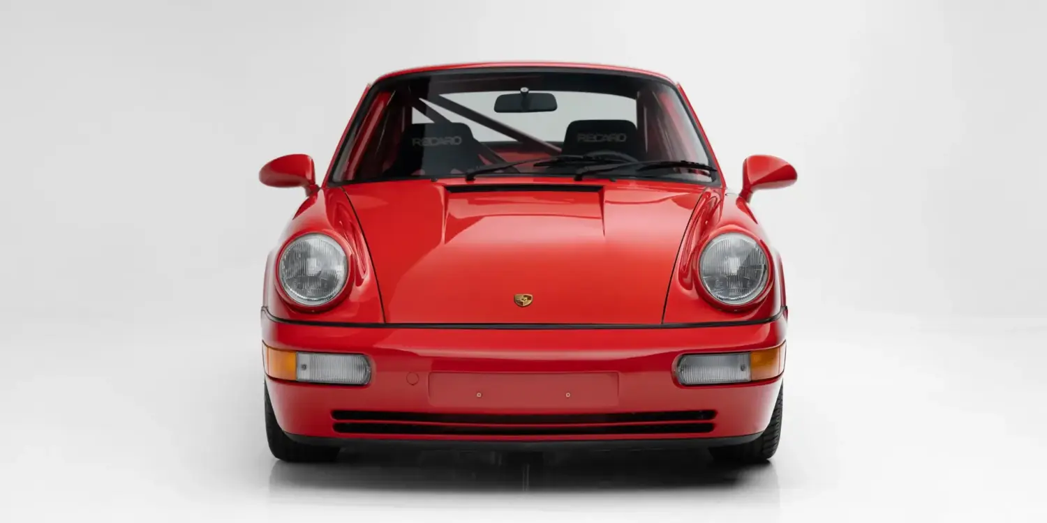 Rote Frontansicht eines Porsche 911 Carrera RS N/GT, Modelljahr 1992, mit sichtbarem Überrollbügel und Recaro-Sitzen.