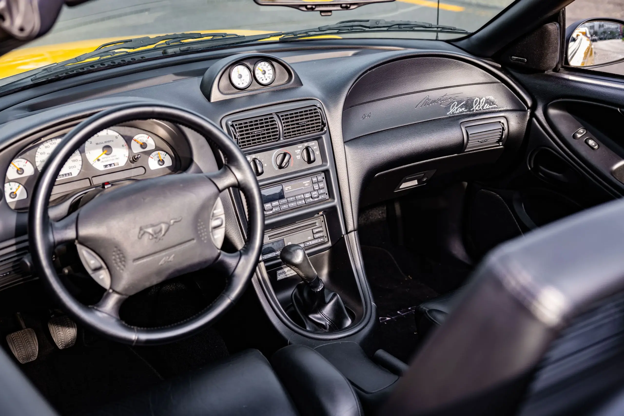 Innenraum des 1995 Saleen Mustang S351 Supercharged Convertible mit signiertem Armaturenbrett, Schaltgetriebe und weißen Saleen-Instrumenten.