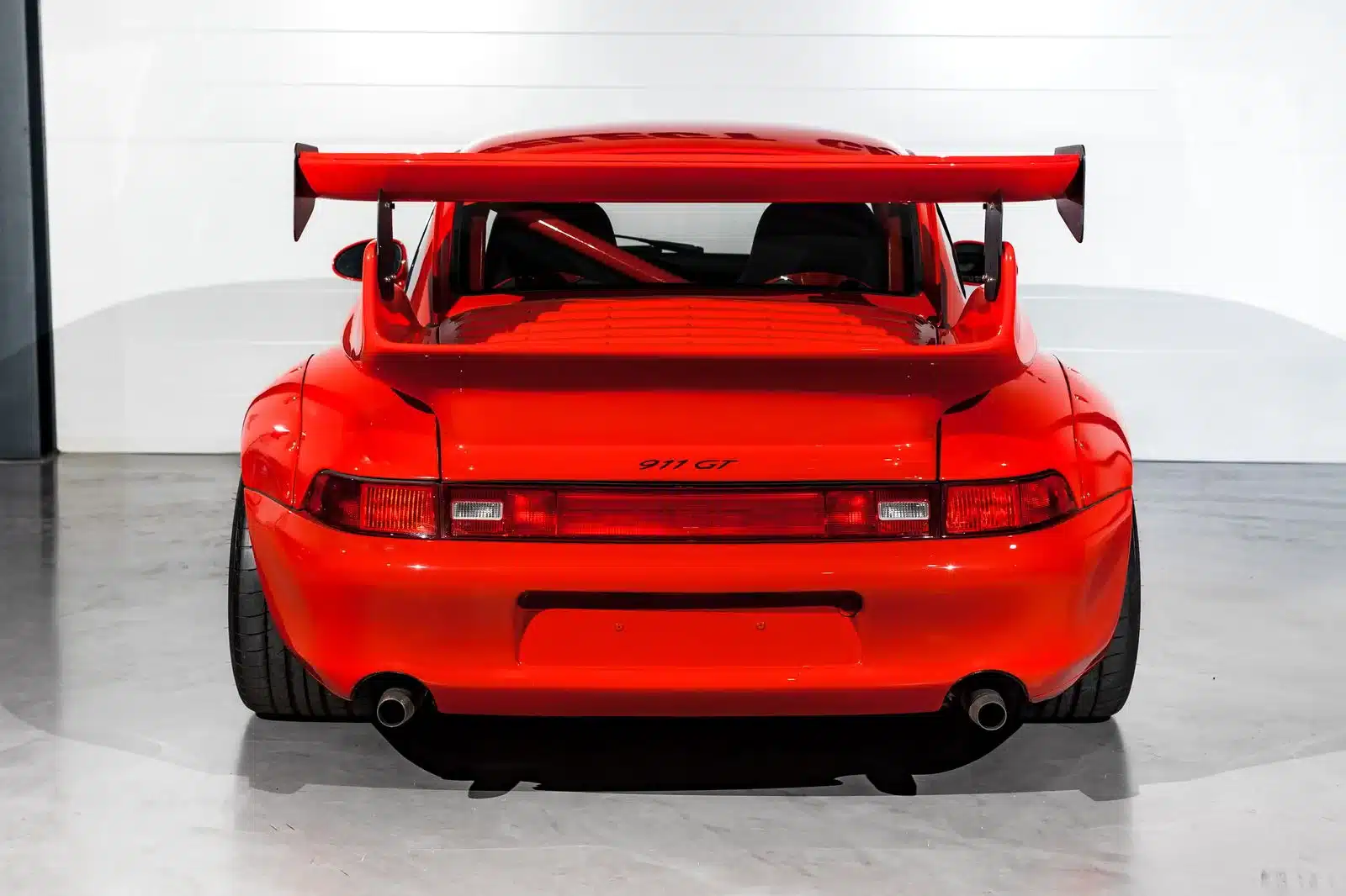 Heckansicht eines roten Porsche 911 GT2-Umbau (993) mit großem Spoiler und „911 GT“-Schriftzug.
