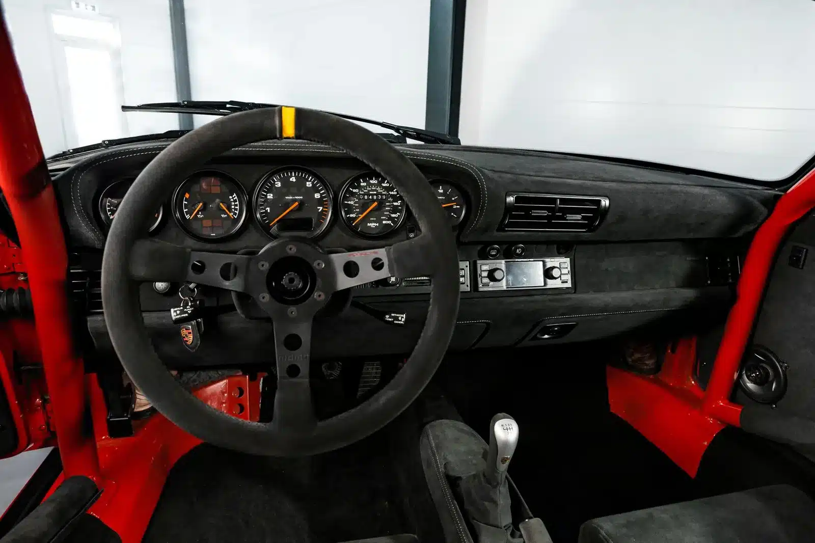 Cockpit und Armaturenbrett eines Porsche 993 Turbo GT2-Umbau mit sportlichem Lenkrad, Überrollkäfig und Alcantara-Ausstattung