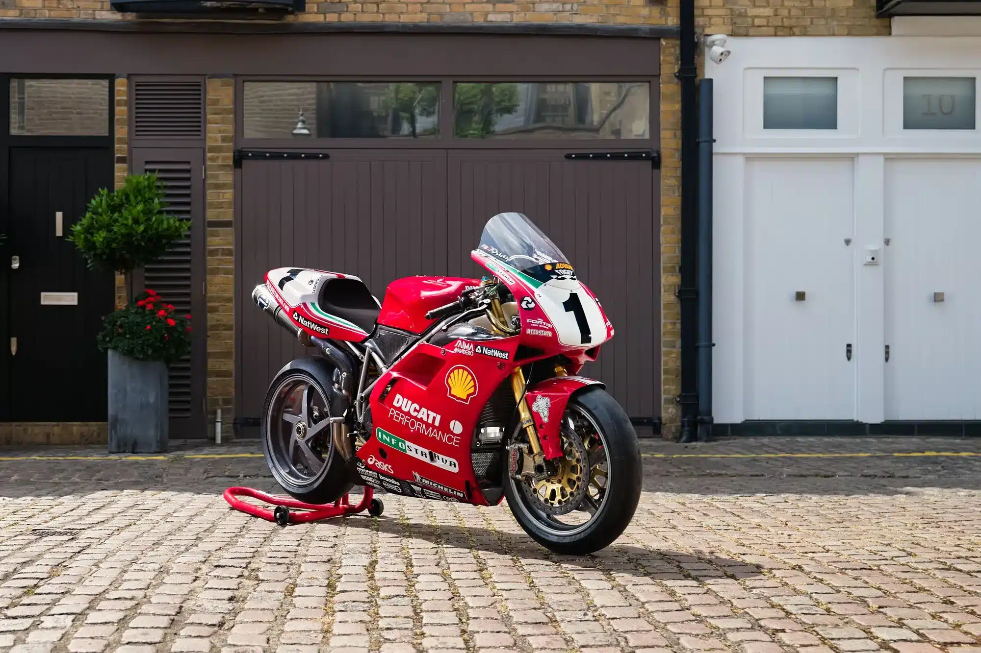 Historische Ducati F99-996 von 1999, ex-Fogarty Werksrennmaschine mit Startnummer 1 auf einem Hof abgestellt.