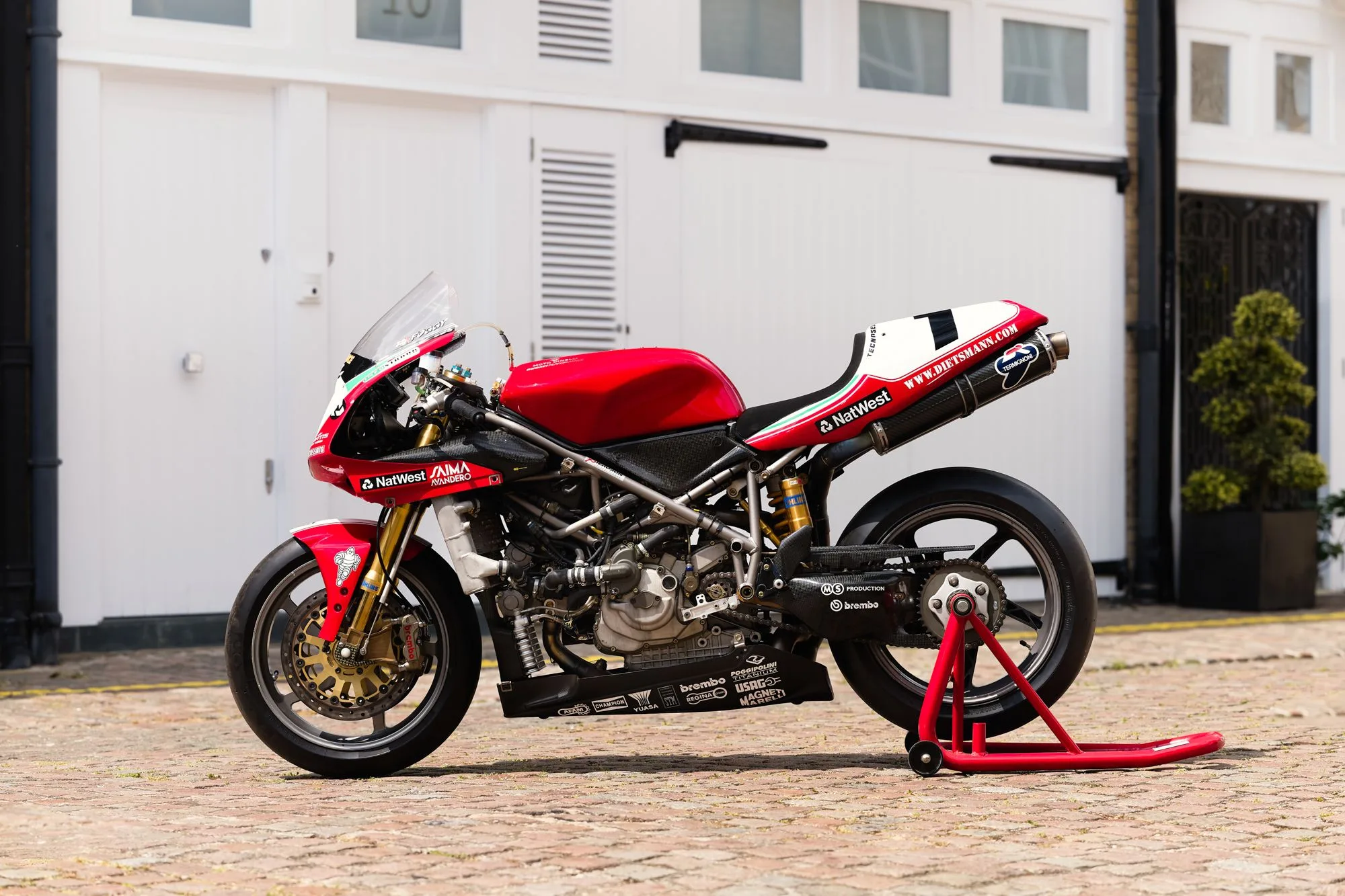 Ducati 996 F99 Werksrennmotorrad von 1999, Seitenansicht mit Rennverkleidung und Startnummer, auf einem Hinterradständer abgestellt.