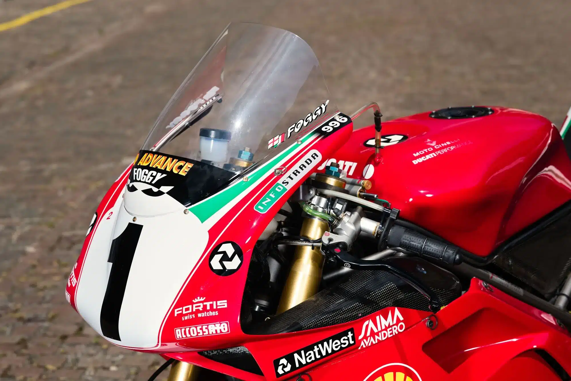 Nahaufnahme des Cockpits und Tanks einer 1999 Ducati 996 Rennmaschine mit Startnummer 1.