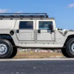 2002 Hummer H1 Wagon in Silber, Seitenansicht mit Dachgepäckträger, auf offener Fläche stehend