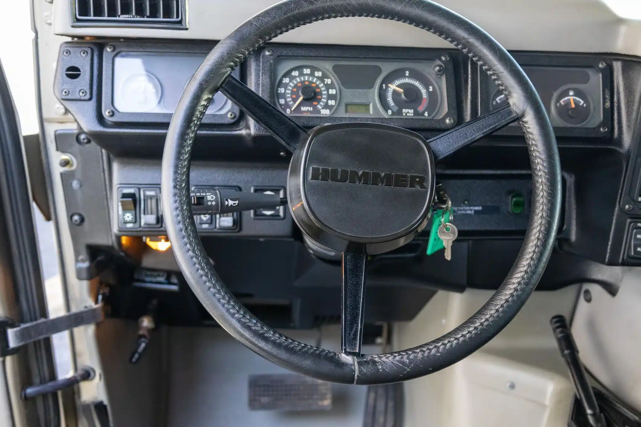 Innenansicht des Hummer H1 Wagon von 2002 mit Lenkrad, Armaturenbrett und Bedienelementen.