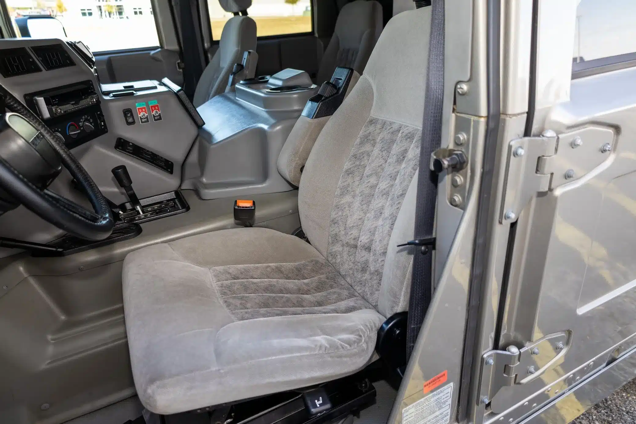 Detailaufnahme des Innenraums eines Hummer H1 Wagon von 2002: Fahrersitz, Mittelkonsole und Armatur