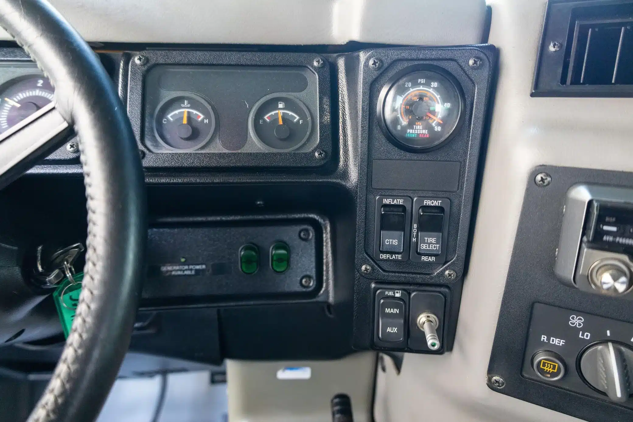 Detailaufnahme vom Armaturenbrett des Hummer H1 Wagon 2002 mit Anzeige und Schaltern für das zentrale Reifendrucksystem (CTIS).