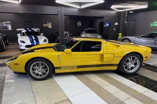 Seitenansicht eines 2006 Ford GT in gelb mit schwarzen Streifen, BBS-Felgen und sportlichem Karosseriedesign.