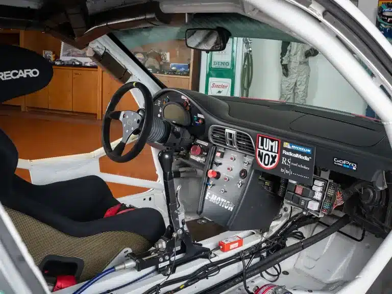 Innenraum eines Porsche 911 GT3 Cup (Baujahr 2007) – detailreiches Cockpit mit Rennlenkrad, Schalthebel und minimierter Ausstattung.