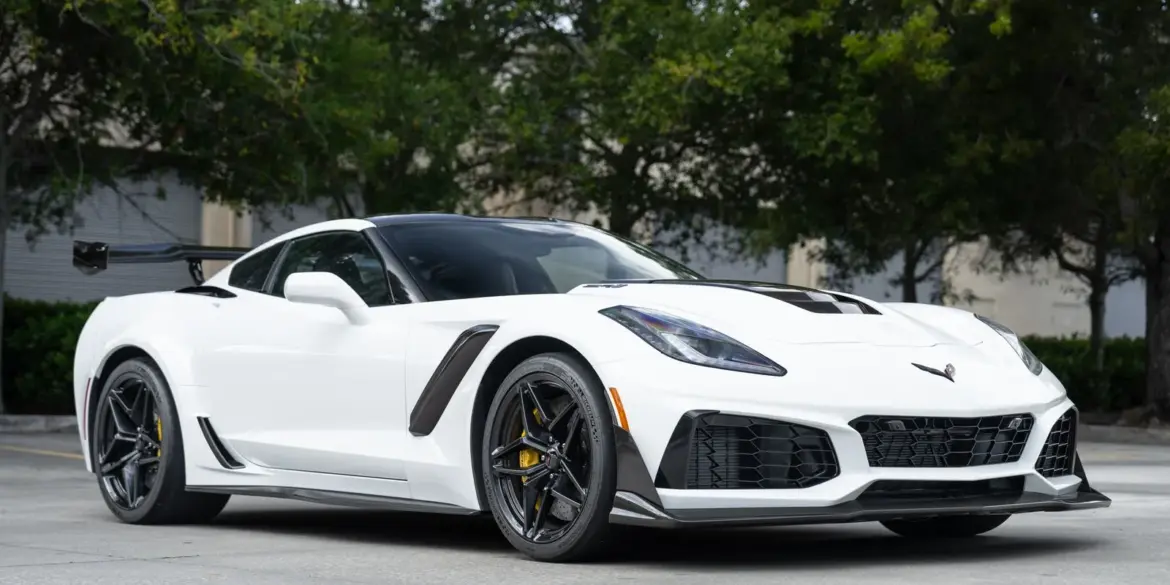 2019 Chevrolet Corvette ZR1 Coupé in Arctic White mit Carbon-Heckflügel und sportlichen Akzenten, Frontansicht, geparkt im Freien.