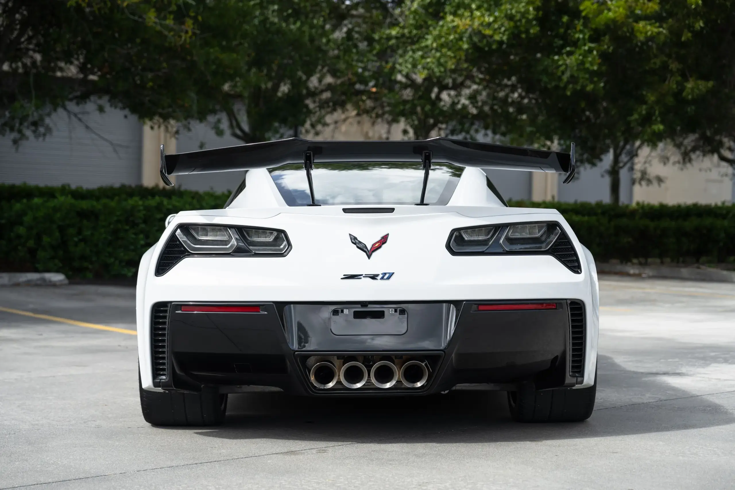 Heckansicht einer weißen Chevrolet Corvette ZR1 Coupé mit großem Carbon-Heckflügel und vier Endrohren im Freien