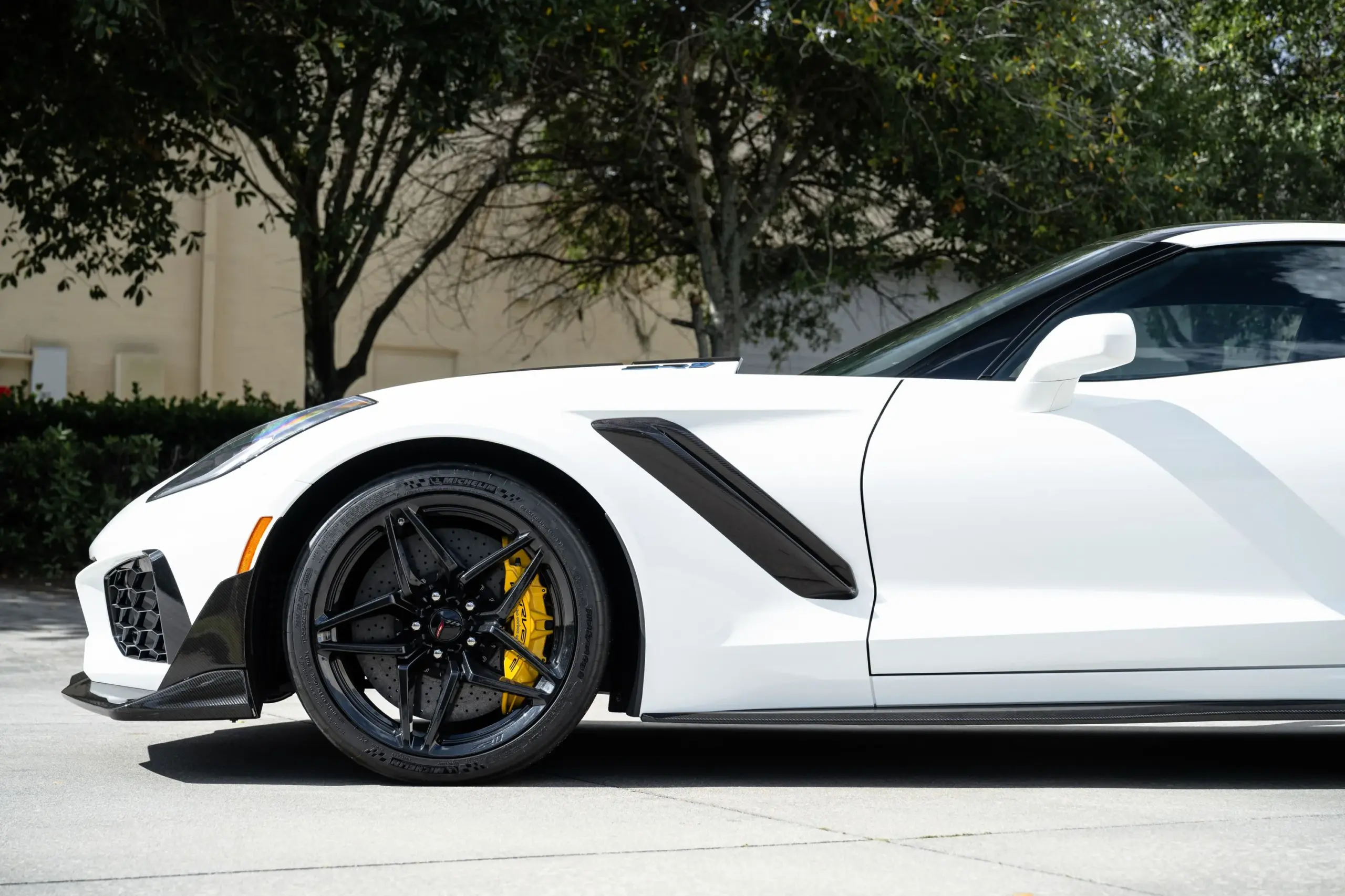 Seitenansicht der weißen Chevrolet Corvette ZR1 mit schwarzen Felgen, gelben Bremssätteln und sichtbaren Carbon-Elementen.