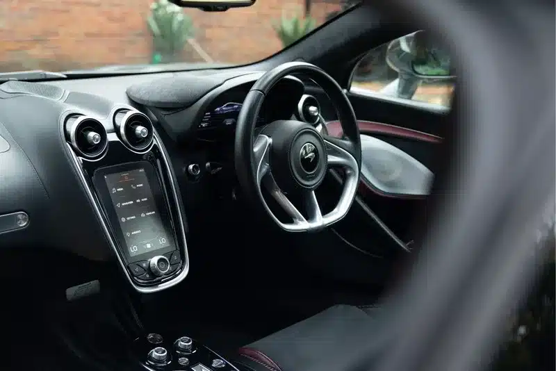 Innenraum des McLaren GT, Modelljahr 2020, mit Rechtslenkung, Touchscreen und exklusivem Lenkrad.