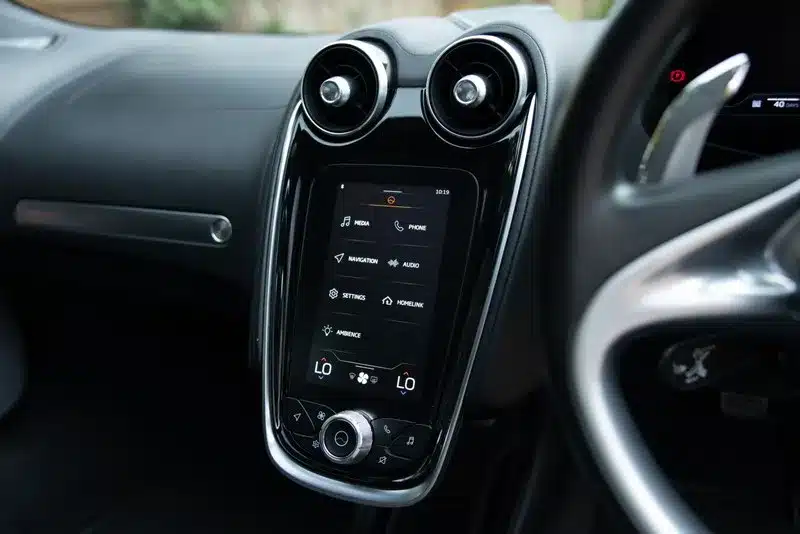 Zentraldisplay und Lüftungsdüsen im Cockpit eines McLaren GT, Baujahr 2020, in Grau.