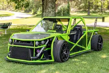 Leuchtend grüner Exotruck GR mit offenem Cockpit, Aluminium-Chassis und sichtbarem Überrollkäfig auf einer Rasenfläche.
