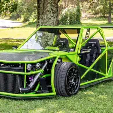 Leuchtend grüner Exotruck GR mit offenem Cockpit, Aluminium-Chassis und sichtbarem Überrollkäfig auf einer Rasenfläche.