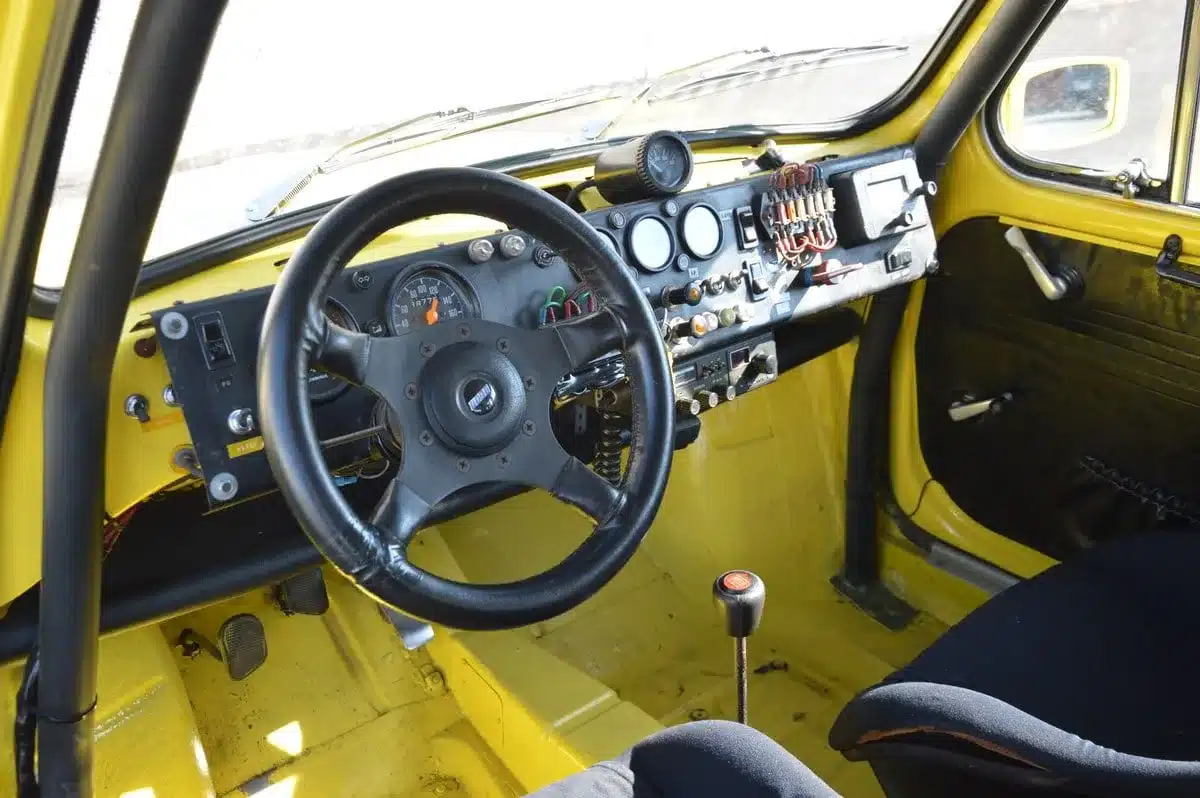 Innenraum der Abarth 600 1050 TC Replica mit Überrollkäfig, Sportsitzen und Rennarmaturen.
