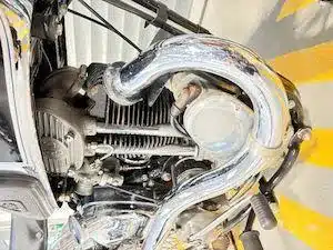 Detailansicht des Motors und Auspuffs einer AJS Model 26 Silver Streak, Baujahr 1938, mit stark verchromten Komponenten.