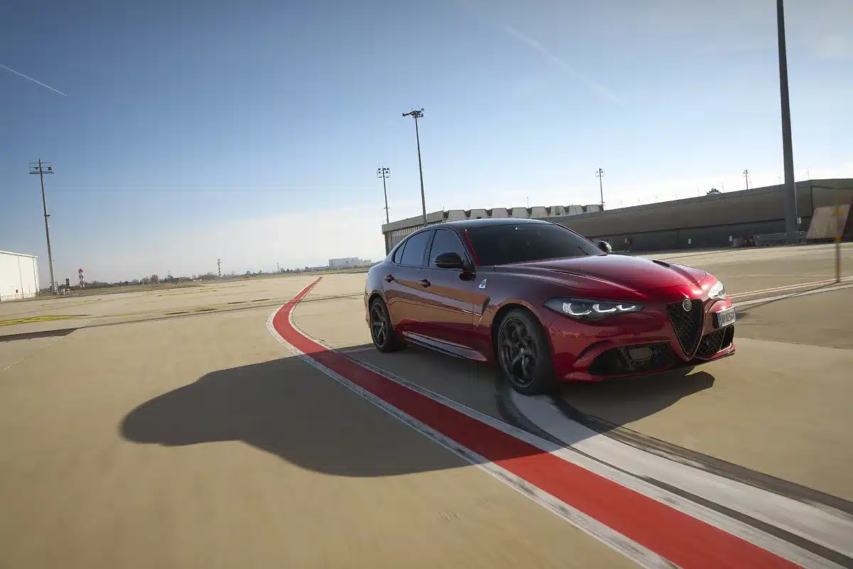 Alfa Romeo Giulia Quadrifoglio Collezione in tiefroter Lackierung fährt auf einer Test- oder Rennstrecke.