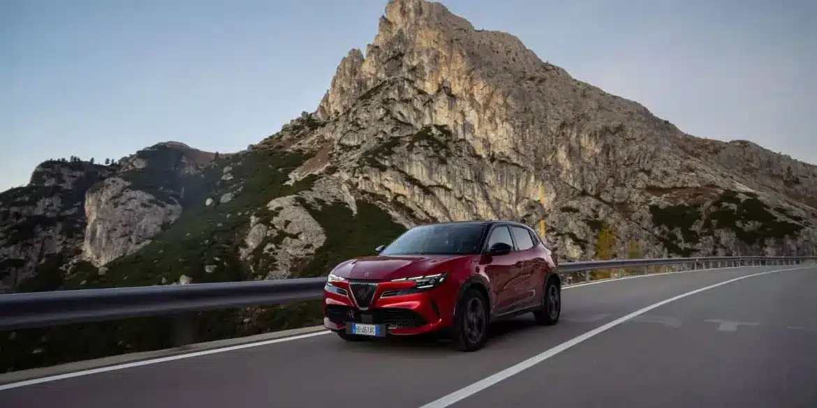 Alfa Romeo Junior MY26 Sport Speciale in Rot fährt auf einer Bergstraße, im Hintergrund hohe Felswände.