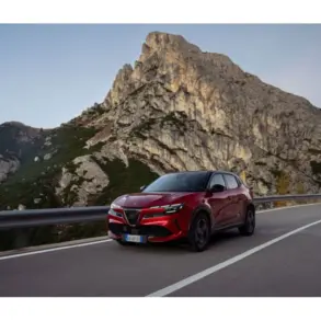 Alfa Romeo Junior MY26 Sport Speciale in Rot fährt auf einer Bergstraße, im Hintergrund hohe Felswände.