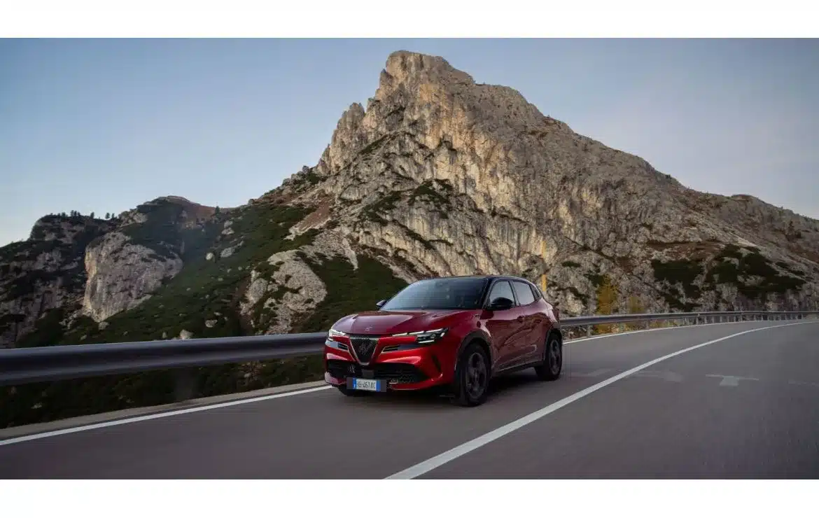 Alfa Romeo Junior MY26 Sport Speciale in Rot fährt auf einer Bergstraße, im Hintergrund hohe Felswände.