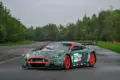 Aston Martin DBR9/5 Rennwagen von 2006 in Grün mit roten Akzenten und Startnummer 008, fotografiert auf einer asphaltierten Strecke.