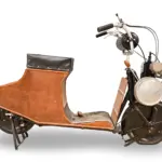 Der 1920 Autoglider 250cc Scooter in kompletter Seitenansicht, mit dreilagiger Holzverkleidung und sichtbarem Zweitaktmotor.