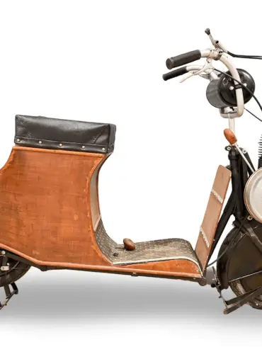 Der 1920 Autoglider 250cc Scooter in kompletter Seitenansicht, mit dreilagiger Holzverkleidung und sichtbarem Zweitaktmotor.