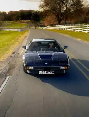 BMW M1 E26 von 1980 in seltener blauer Lackierung fährt auf einer Landstraße.