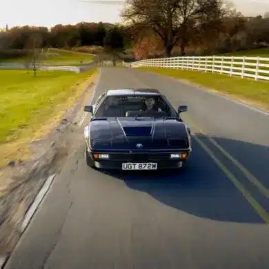 BMW M1 E26 von 1980 in seltener blauer Lackierung fährt auf einer Landstraße.