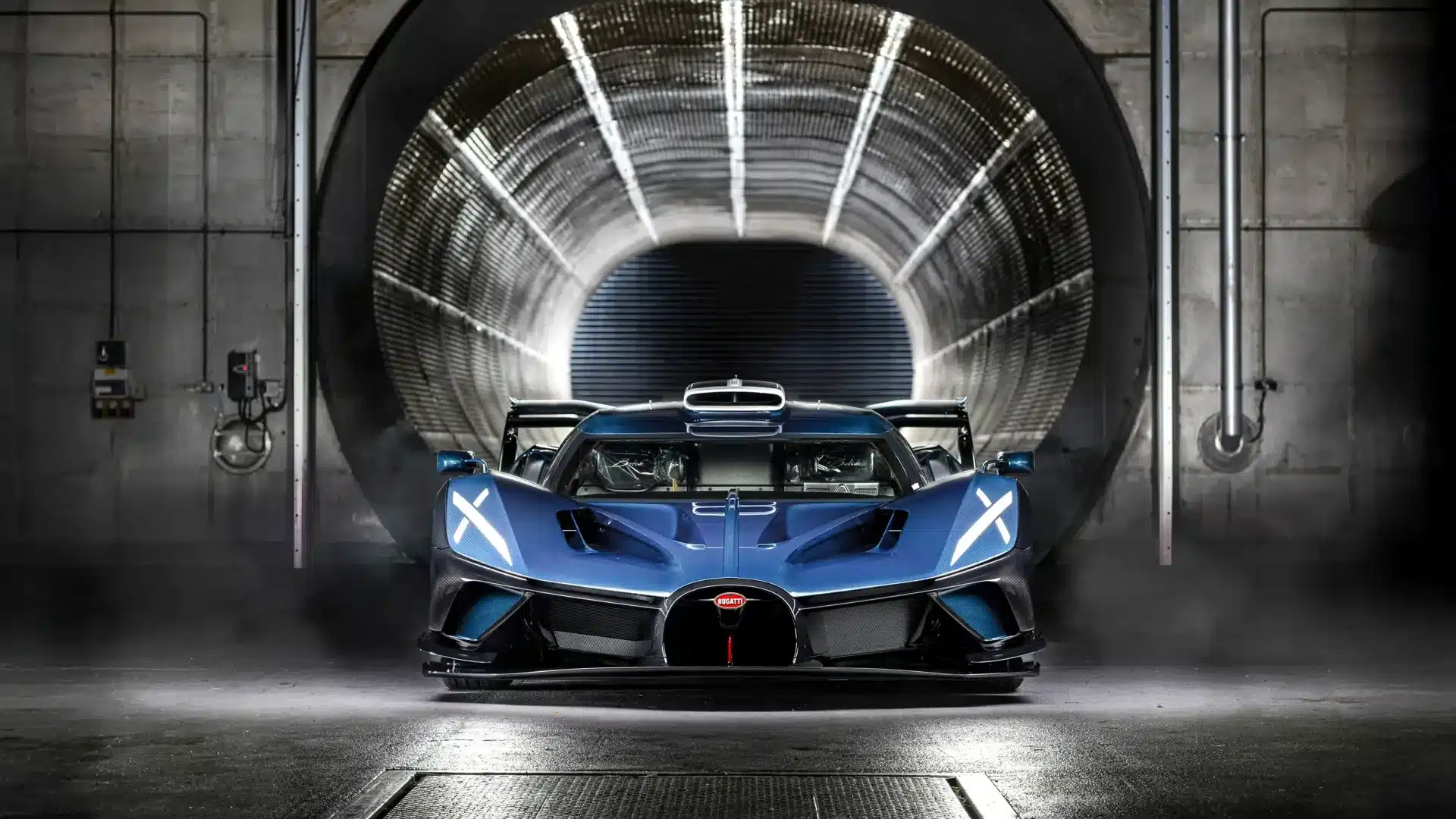 Frontansicht eines blauen Bugatti Bolide Hypercars im Windkanal, Rennfahrzeug mit ausgeprägten Aerodynamik-Elementen.