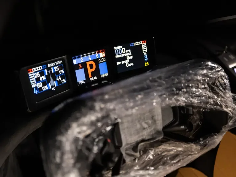 Nahaufnahme der digitalen Instrumententafel und des Lenkrads vom Bugatti Bolide, eingepackt in Schutzfolie.