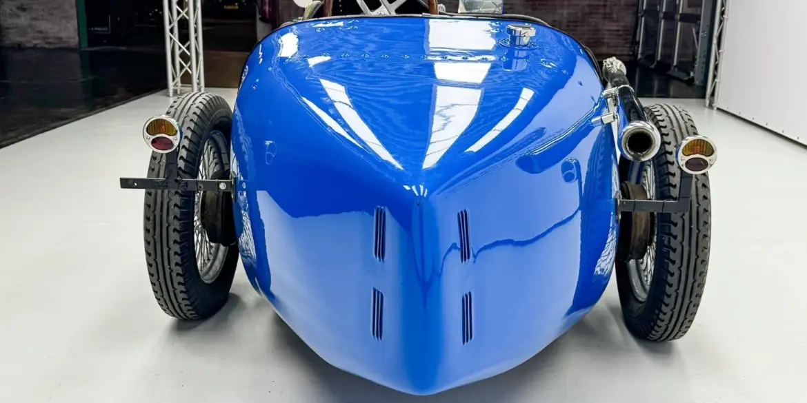 Heckansicht eines blauen Bugatti Creation Cabriolet von 1971 mit Speichenrädern und zwei Edelstahlauspuffendrohren, aufgenommen in einer Halle.