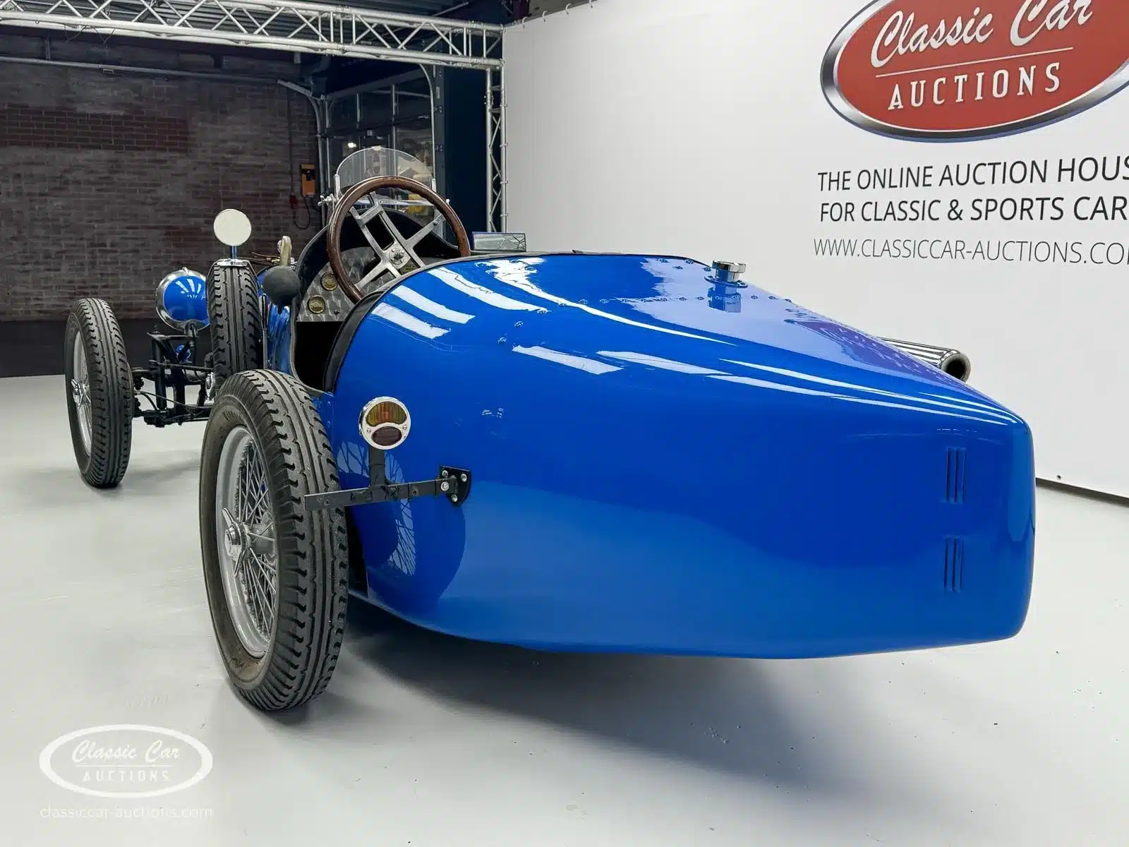 Frontalansicht eines Bugatti Creation Cabriolet von 1971, tiefblau lackiert, mit Speichenrädern und offenem Cockpit bei Classic Car Auctions.