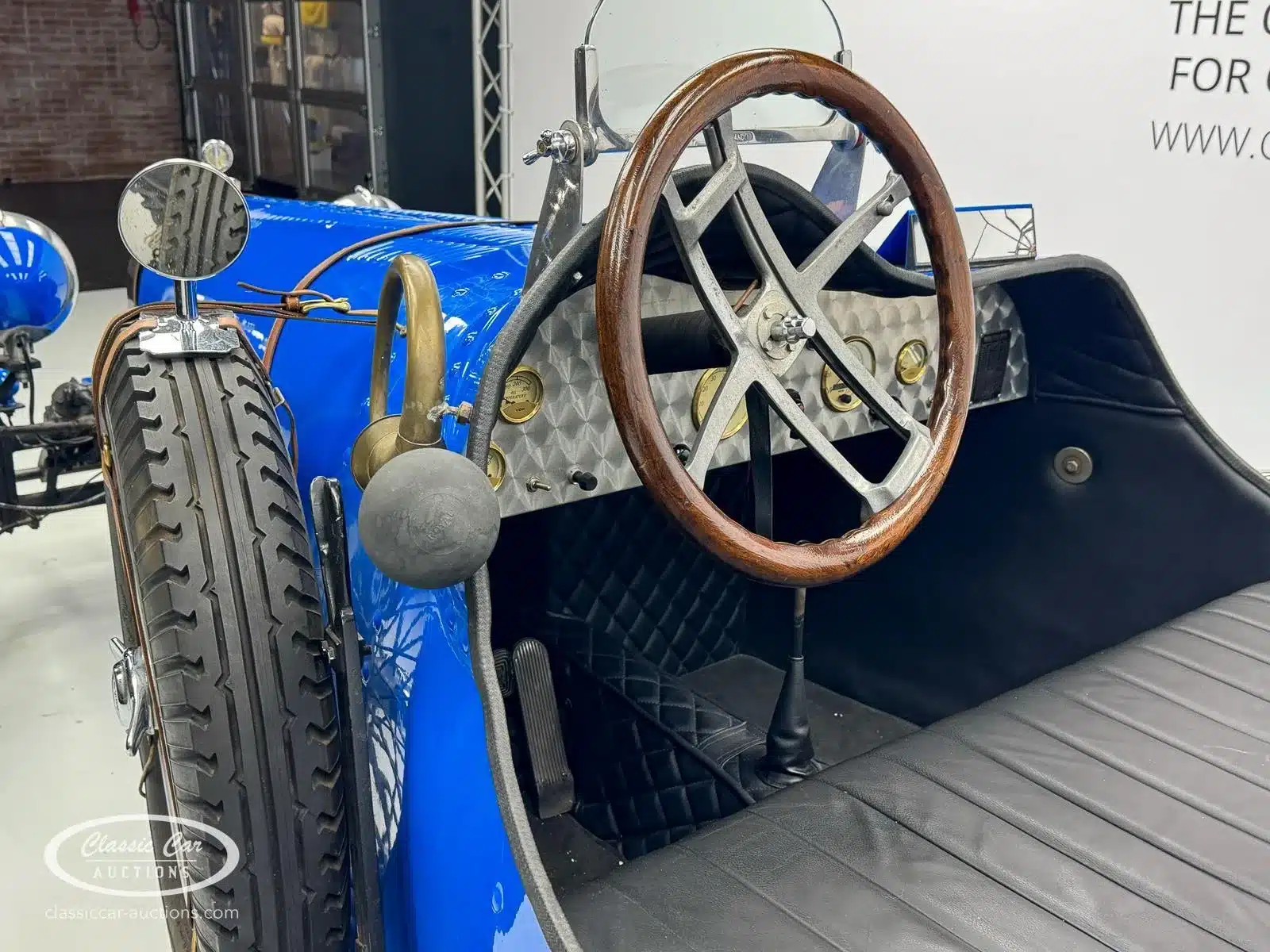 Innenraum eines Bugatti Creation Cabriolet von 1971 mit klassischem Holzlenkrad, analogen Instrumenten und Lederausstattung.