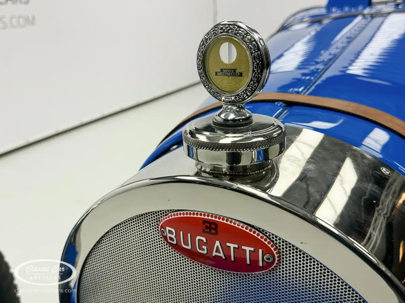 Frontansicht des Kühlergrills eines blauen Bugatti Creation Cabriolets von 1971 mit Boyce Motometer und Bugatti-Emblem.
