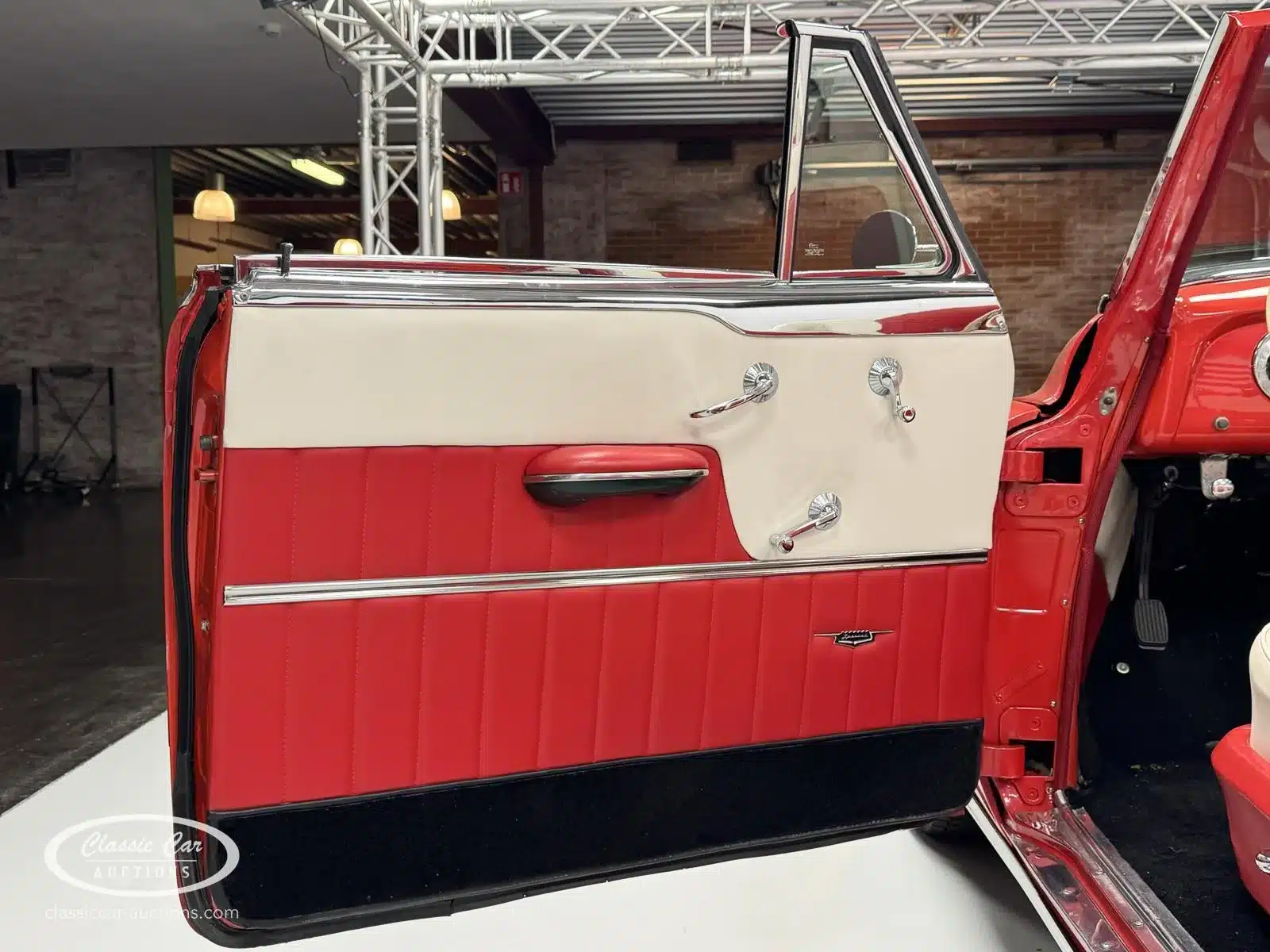 Offene Tür eines Buick Special 40 Cabriolet von 1953 mit rot-weißer Innenverkleidung und Chromdetails