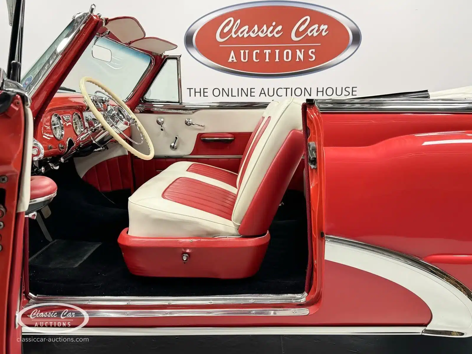 Innenansicht eines roten 1953 Buick Special 40 Cabriolets mit cremefarben-roten Sitzen und klassischem Lenkrad