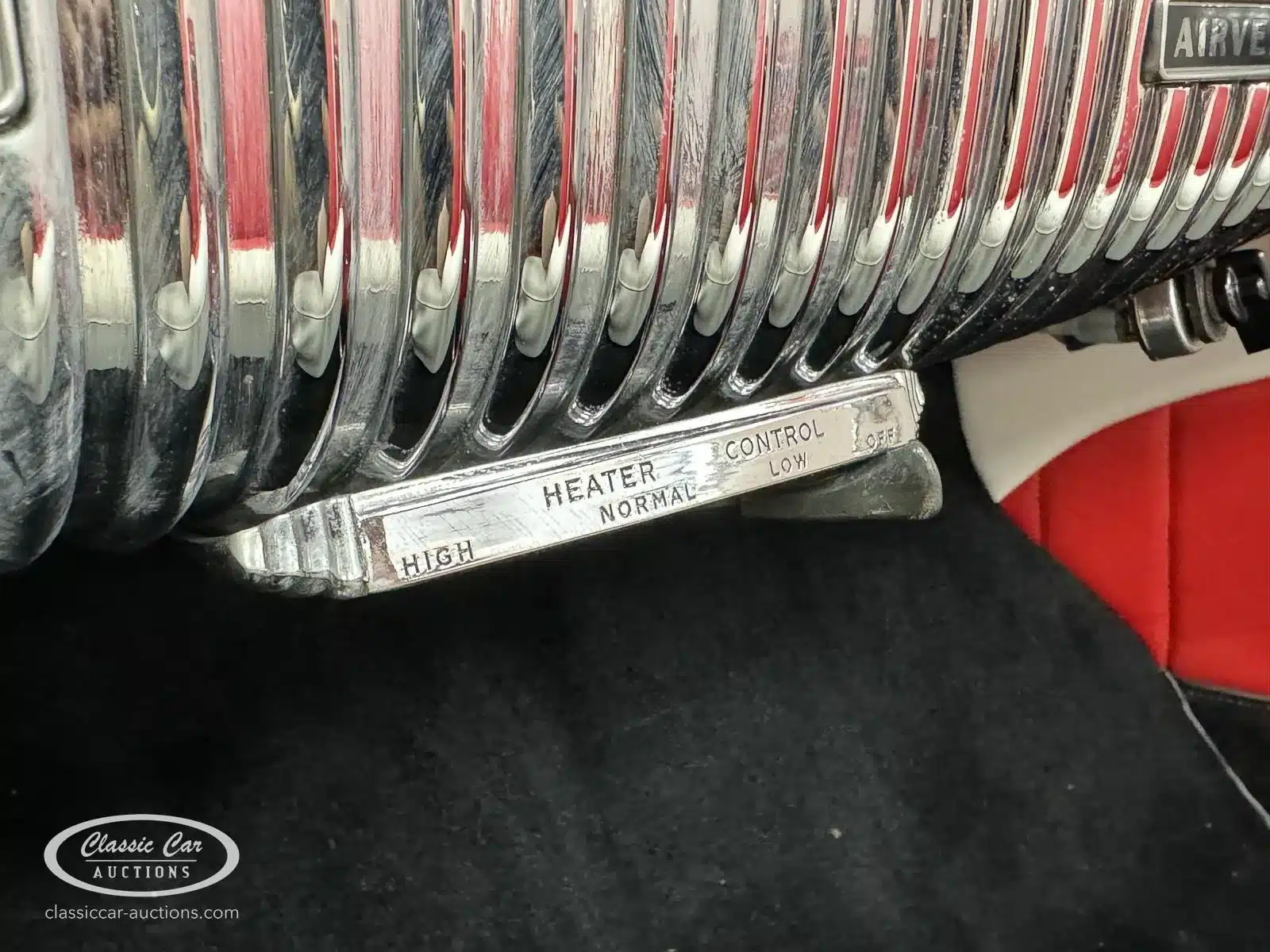 Detailaufnahme der Heizungskontrolle und Chromverkleidung im roten Innenraum eines Buick Special 40 von 1953