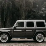 Seitenansicht eines Carlex G63 Havana Vintage, basierend auf der Mercedes G-Klasse, in elegantem Sepia-Ton vor bewaldetem Hintergrund.