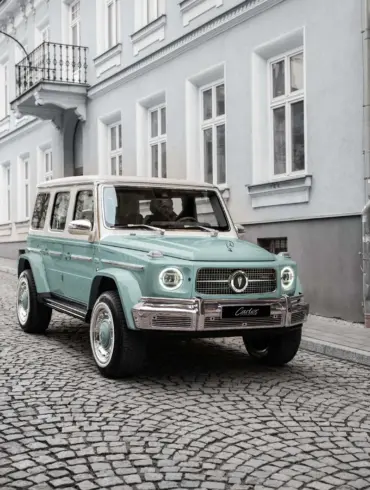 Frontansicht des Carlex G63 Lago Vintage in mintgrüner Lackierung auf Kopfsteinpflaster, parkend vor einem Altbau.