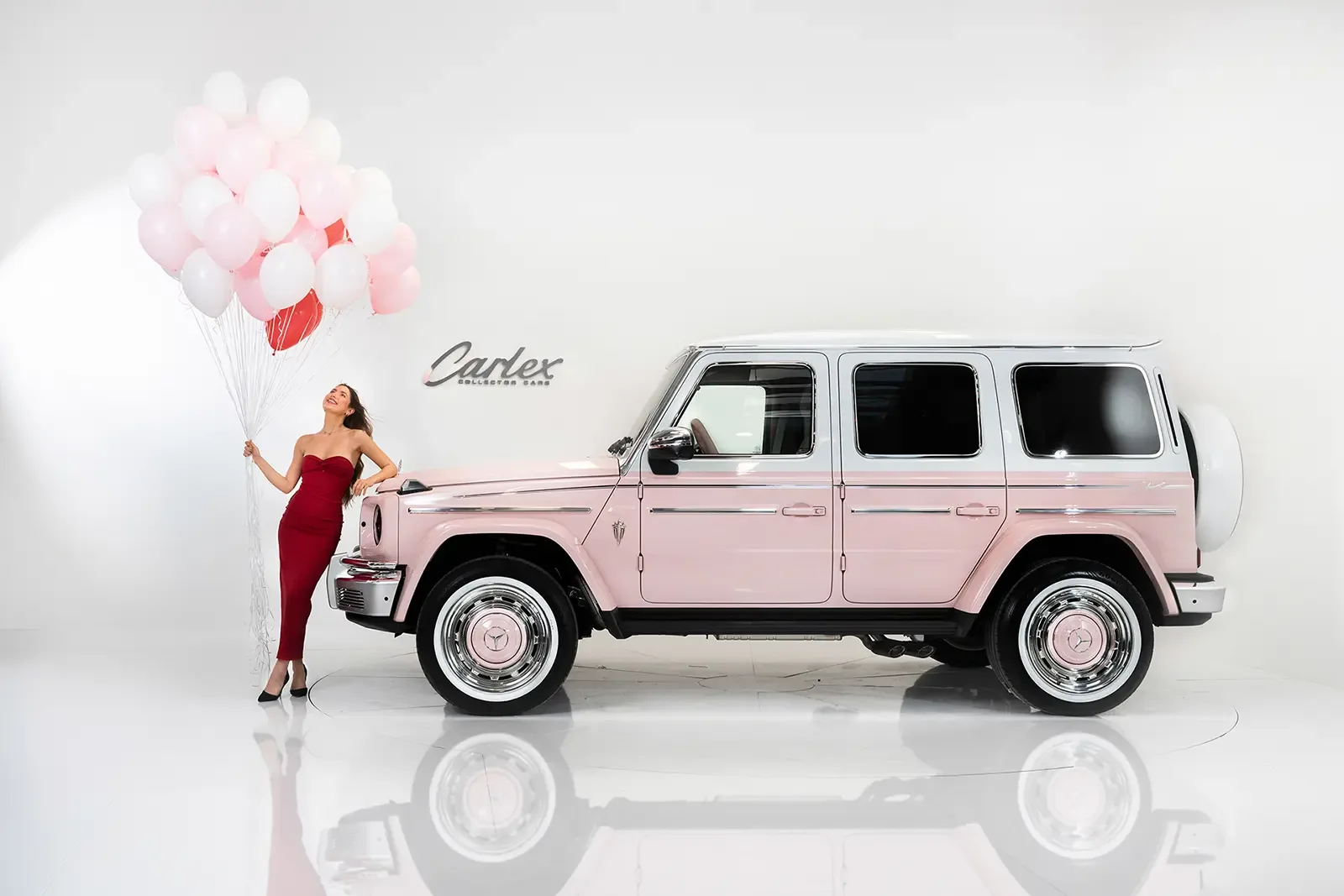 Carlex G63 Rose Vintage mit roséfarbener Lackierung und einer Frau mit Ballons daneben, seitliche Ansicht des Fahrzeugs.