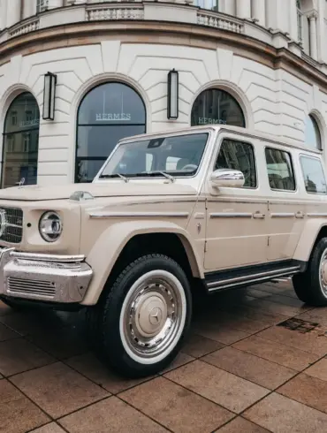 Sandfarbener Carlex G63 Sabbia Vintage mit klassischen Designelementen vor einem historischen Gebäude in der Stadt.