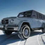 Carlex G63 Sky Vintage: Mercedes-AMG G-Klasse Sonderedition in Blautönen, geparkt auf verschneitem Feld, Frontansicht mit klarer Winterlandschaft im Hintergrund.