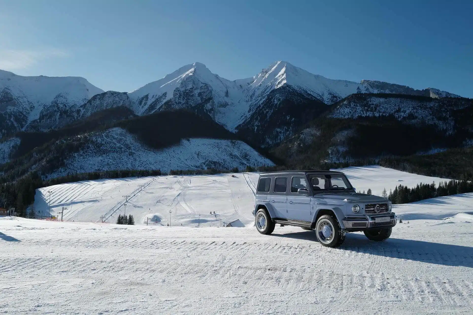 Carlex G63 Sky Vintage in abgestuften Blautönen vor schneebedeckten Bergen.