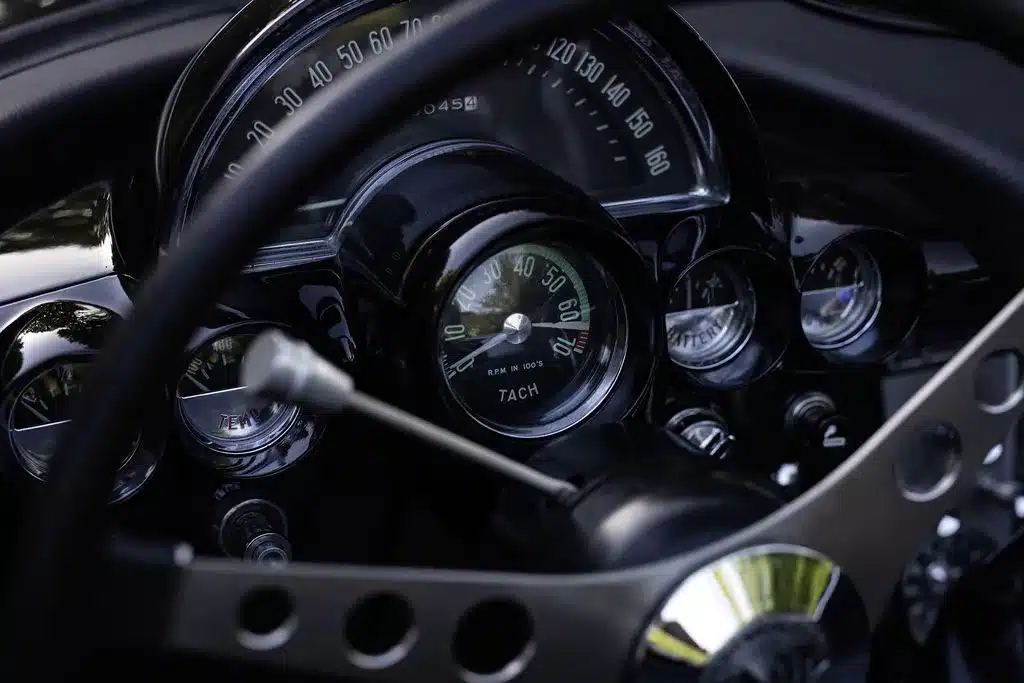 Armaturenbrett und Tachometer einer Chevrolet Corvette C1 Cabriolet von 1961, schwarz mit klassischen Rundinstrumenten.